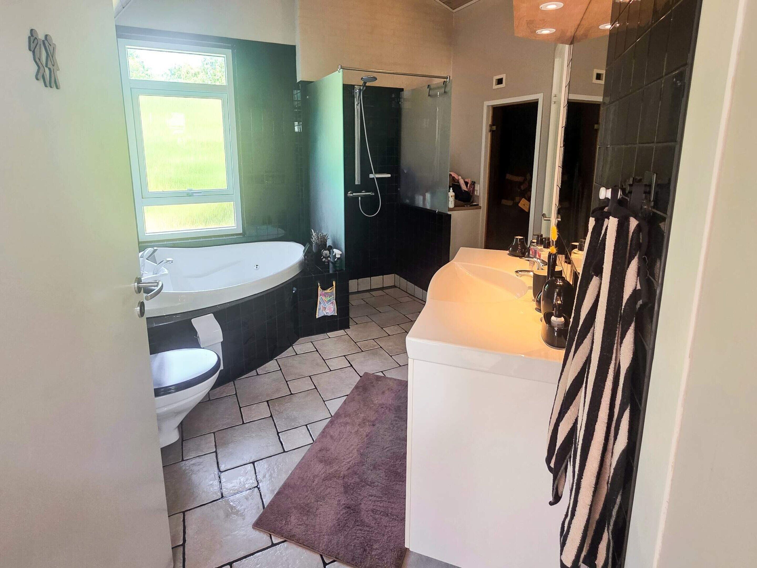 A bathroom with a bathtub, toilet, and sink.