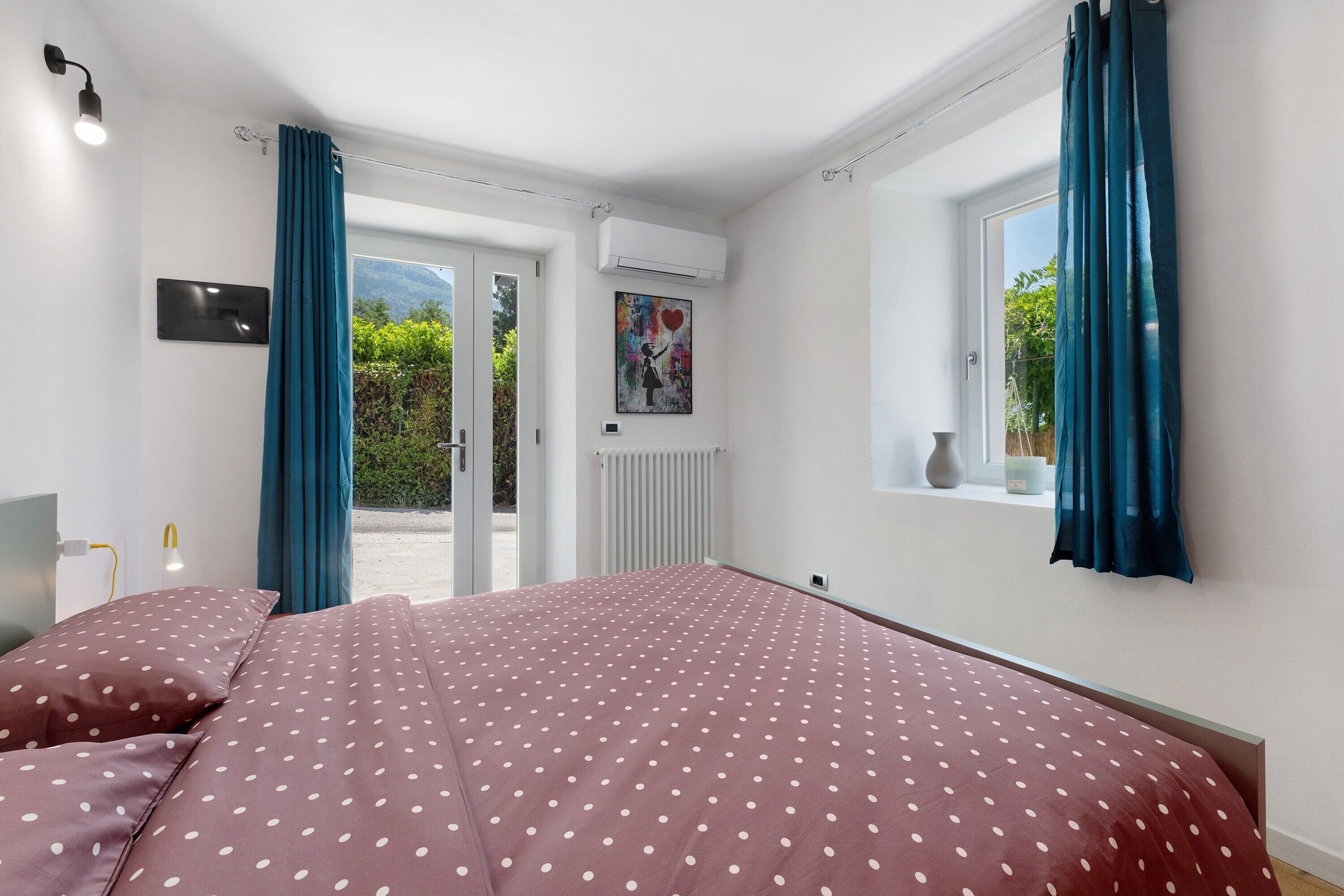 Un dormitorio con cama, cortinas, una ventana y un radiador.