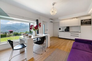 A modern kitchen with white cabinets, a built-in oven, and a microwave.