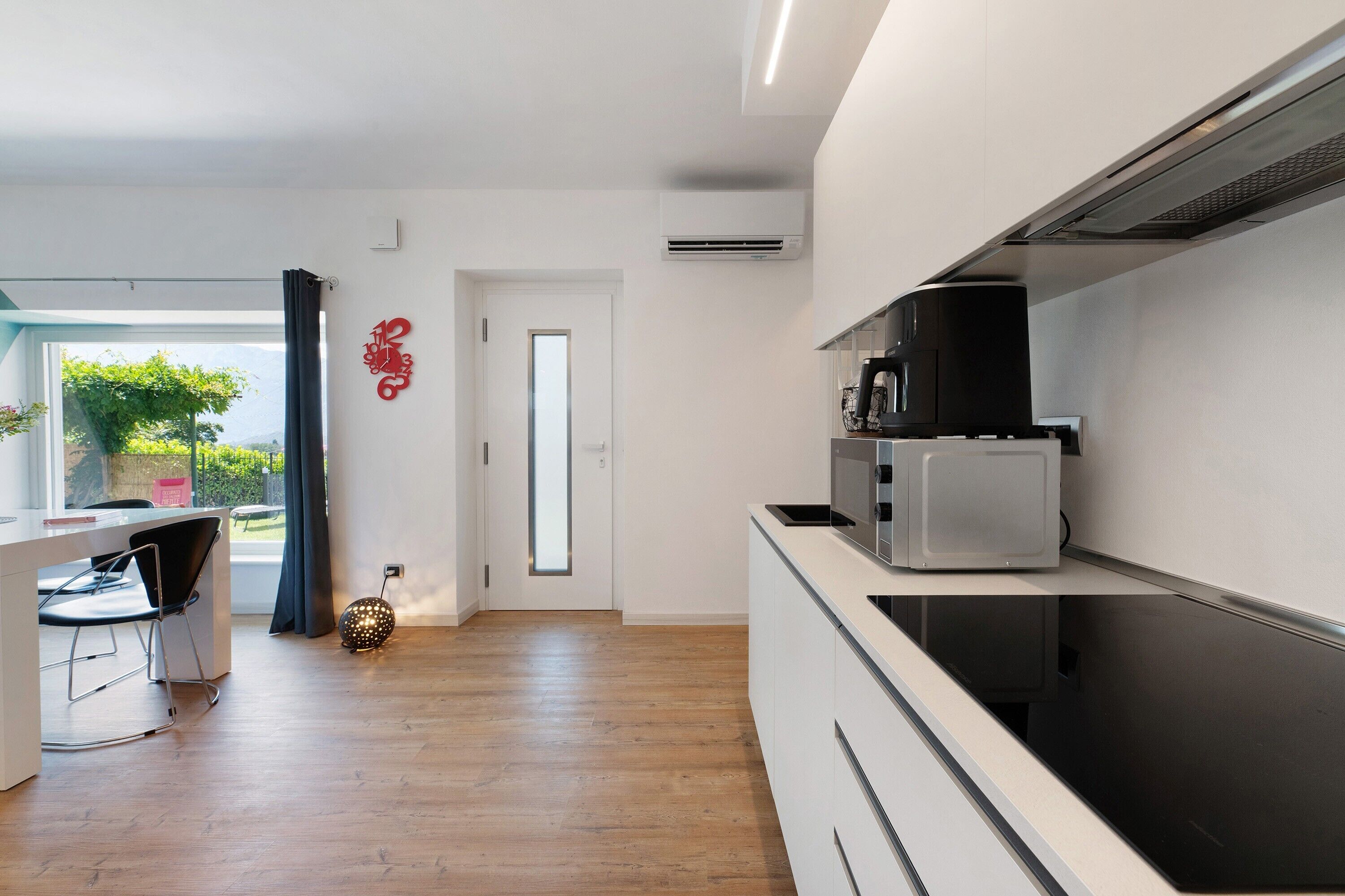 Una cocina moderna con microondas integrado y cafetera sobre la encimera.