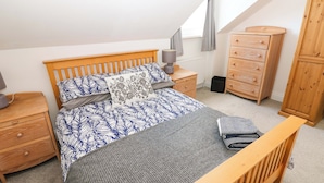 A bedroom with a bed, nightstands, a dresser, a wardrobe, and a window with curtains. - 8 Percy Terrace (Sunderland)