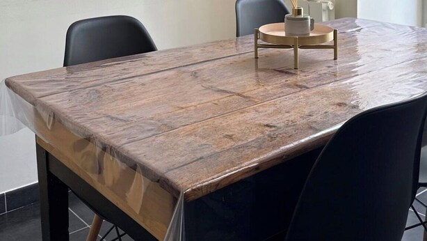 A wooden dining table with chairs, a small decorative item, and a white wall. - Apartment in the heart of Annonay (Annonay)