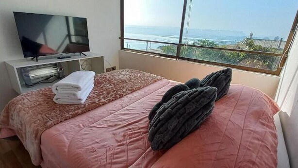 Ein Schlafzimmer mit einem Bett, einem Fernseher und einem Fenster mit Blick.
