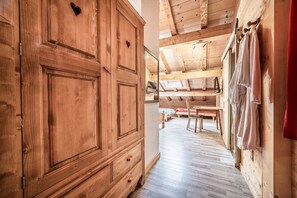 A wooden interior with a wardrobe, a bench, and a table.