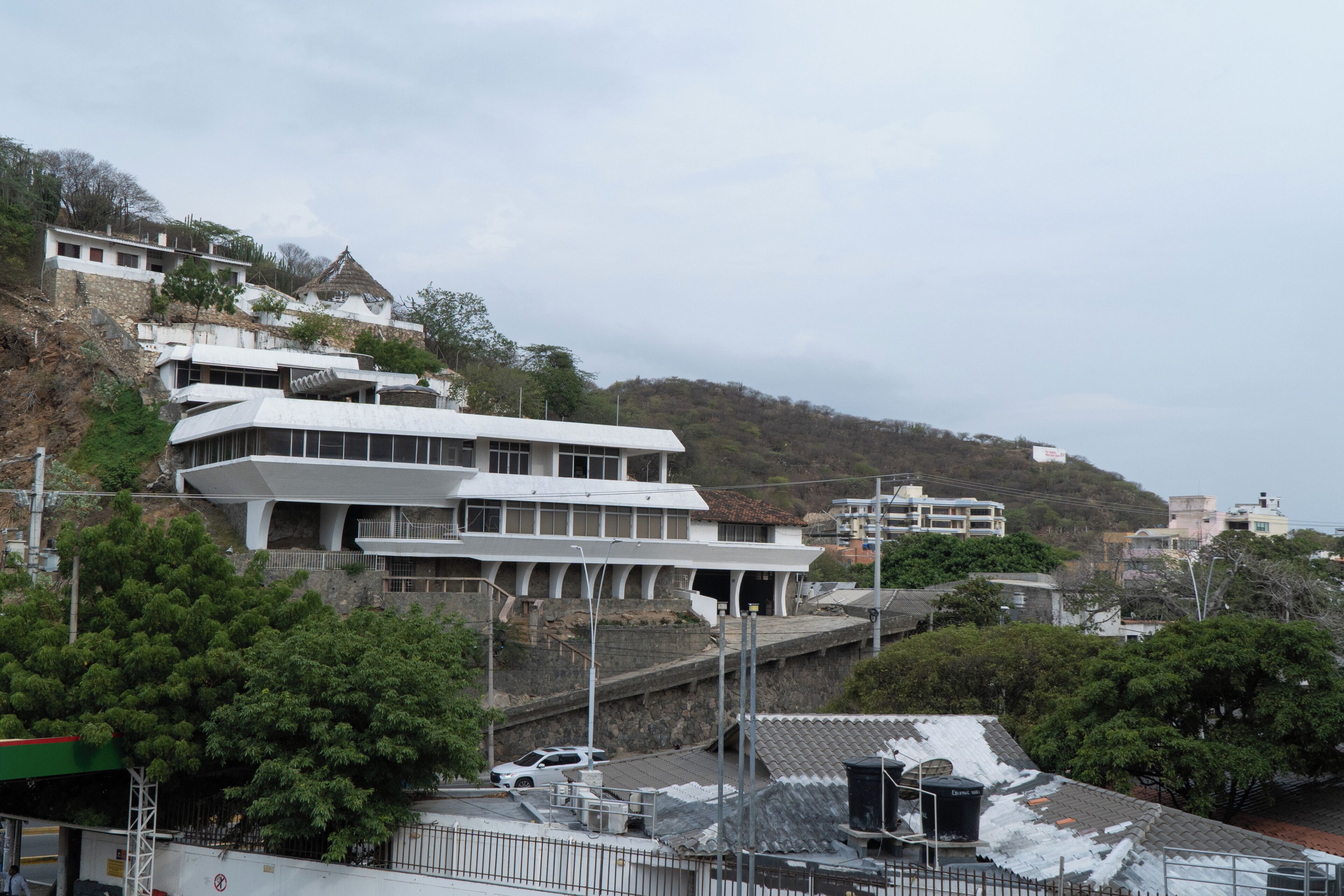 A modern building with multiple floors, a sloped roof, and a staircase leading to the entrance.