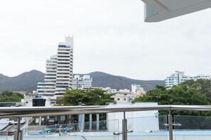 Un edificio moderno con un diseño angular distintivo, rodeado de vegetación y montañas al fondo.