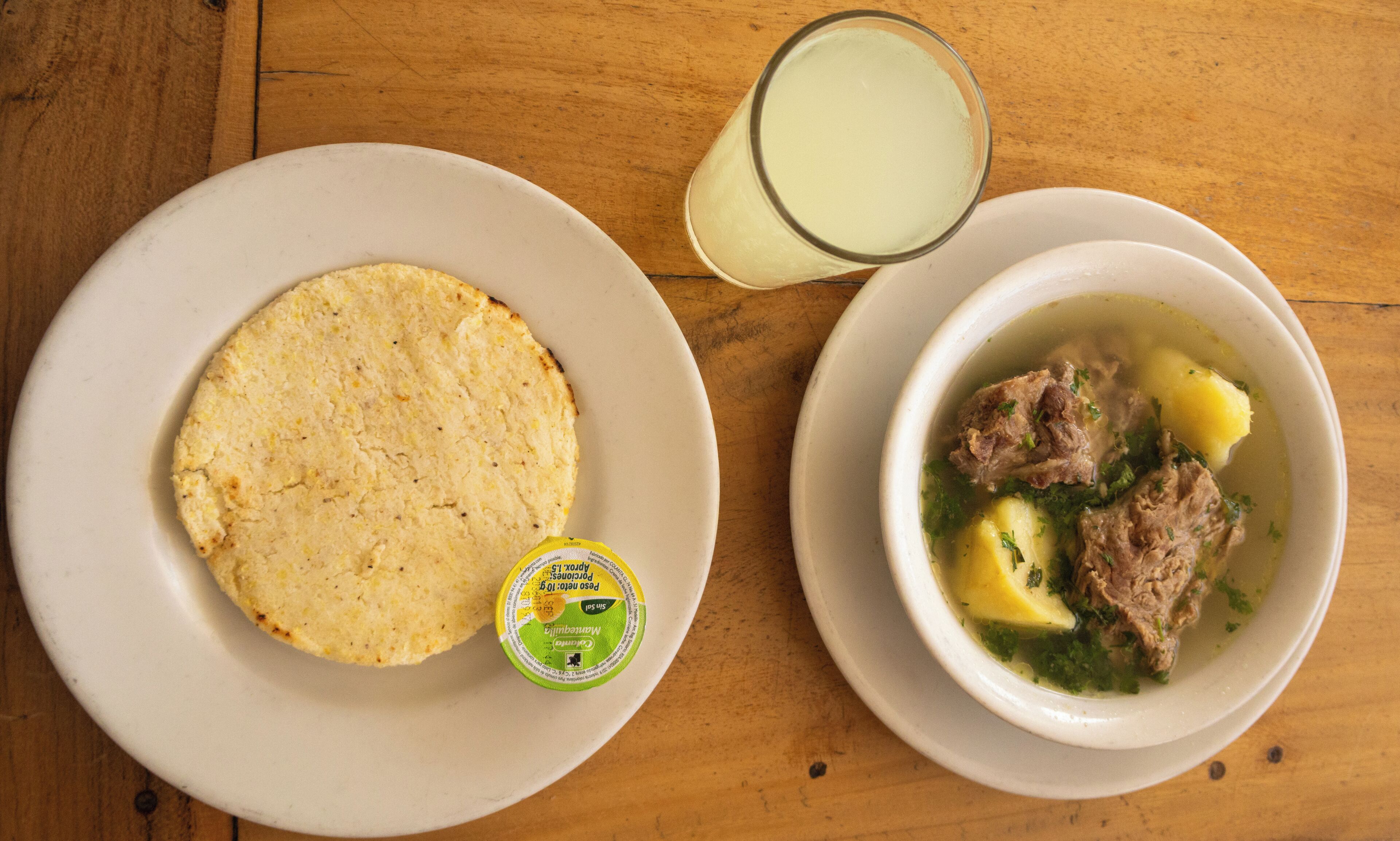 Un piatto con una flatbread e una ciotola di zuppa con carne e patate.