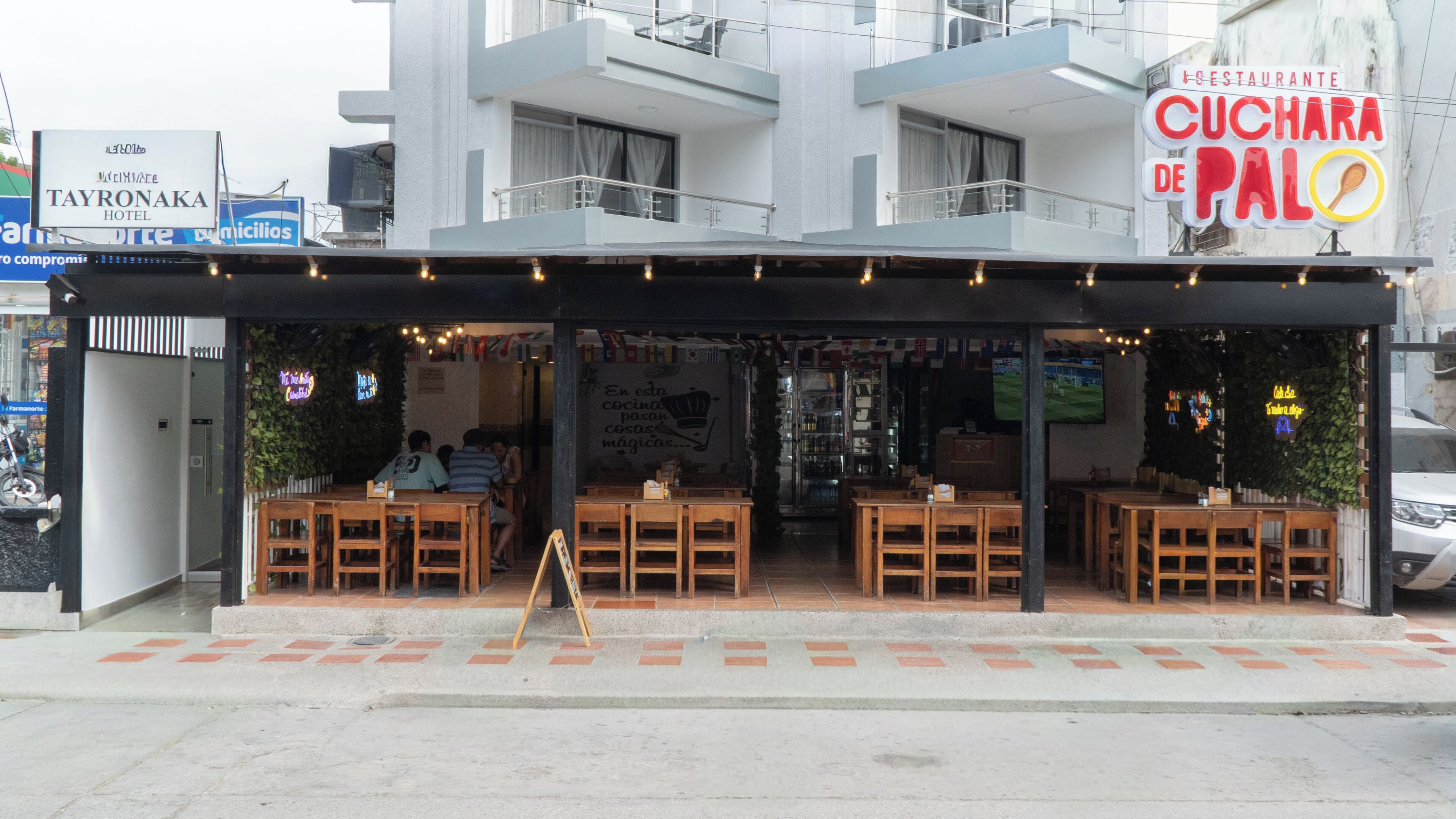 A restaurant with outdoor seating and a sign for 'CUCHARA DE PALO'.