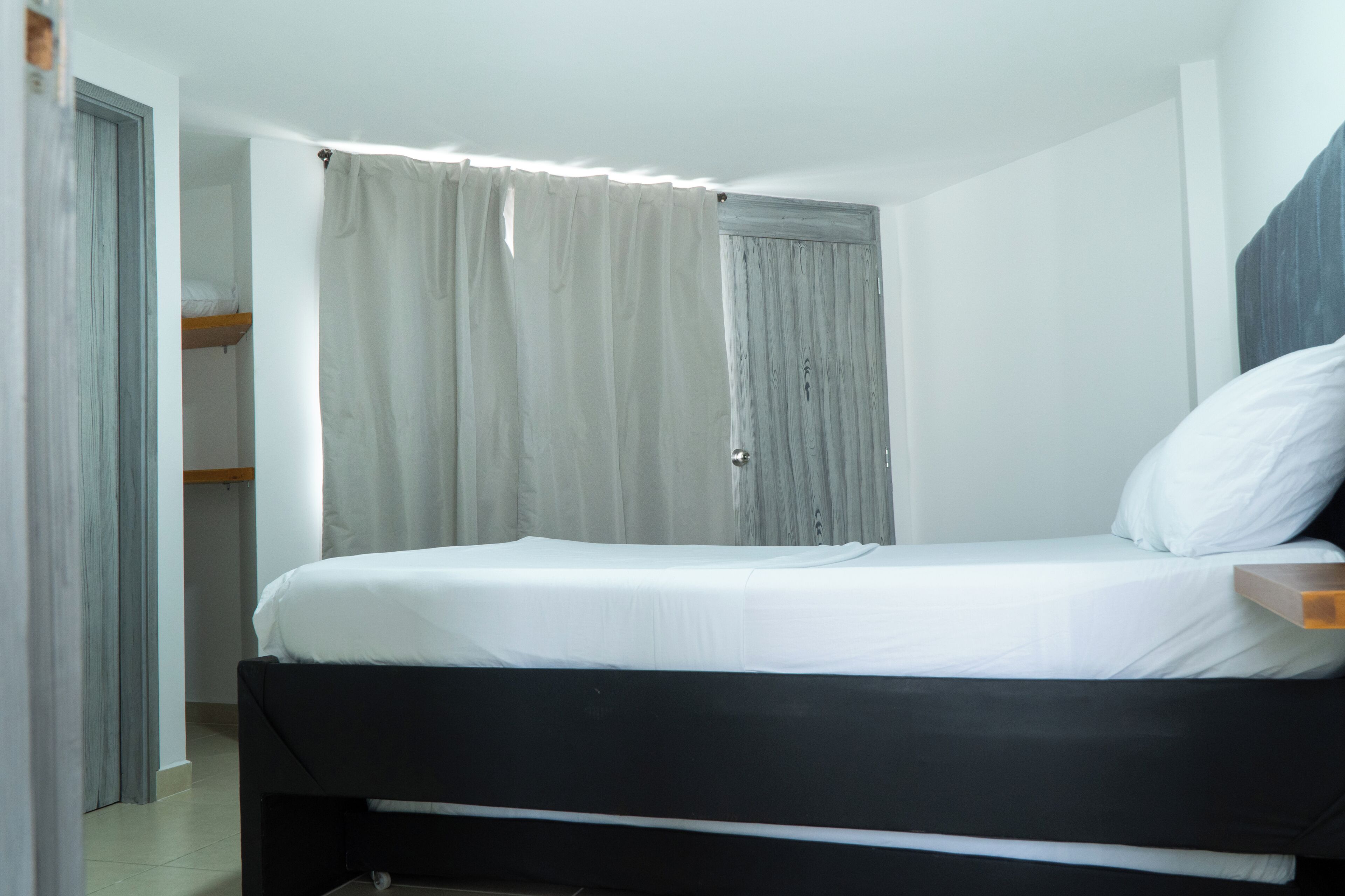 A bedroom with a single bed, a wardrobe, and a door.