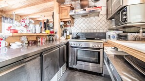 A kitchen with wooden cabinets, a stainless steel oven, and a microwave.
