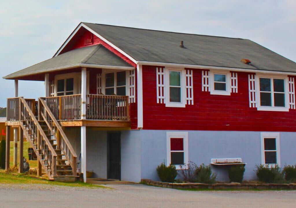 A two-story building with a balcony, a staircase, and a garage.