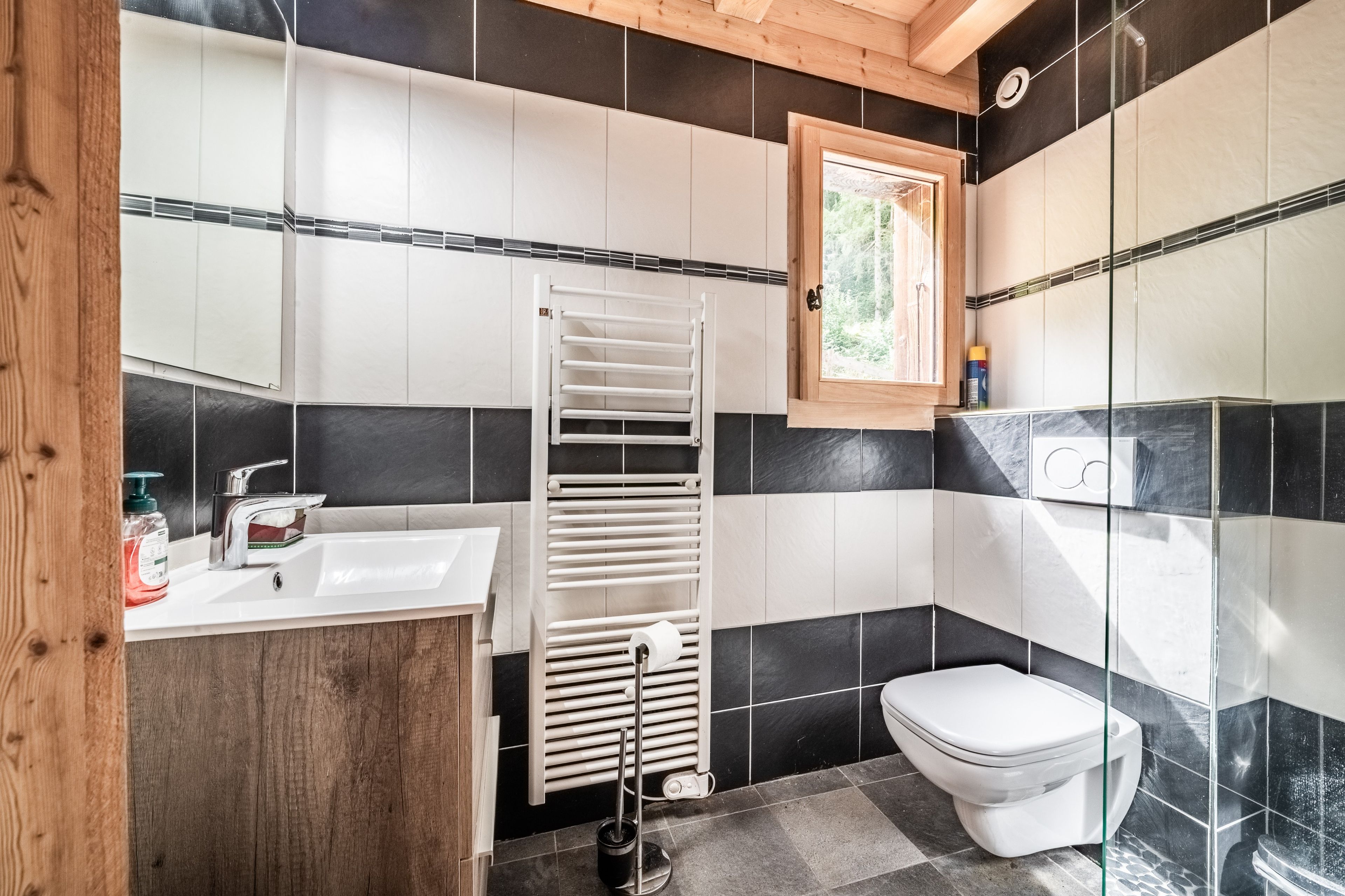 Un baño con lavamanos blanco, inodoro y zona de ducha.