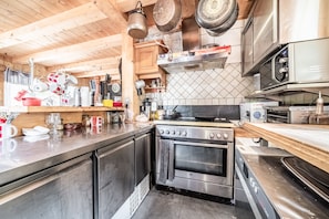 A kitchen with wooden cabinets, a stainless steel oven, and a microwave.