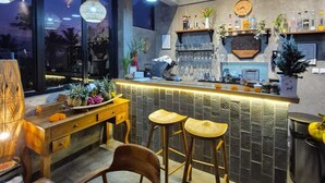 A bar area with a counter, stools, and a view of the outside.