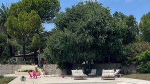 A swimming pool with lounge chairs, a stone wall, and trees. - Studio on the top floor of a traditional Grasse country house (Grasse)