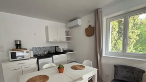 A compact kitchen with a microwave, coffee maker, and a small dining table with chairs. - Studio on the top floor of a traditional Grasse country house (Grasse)
