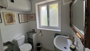 A bathroom with a toilet, sink, and window. - Studio on the top floor of a traditional Grasse country house (Grasse)