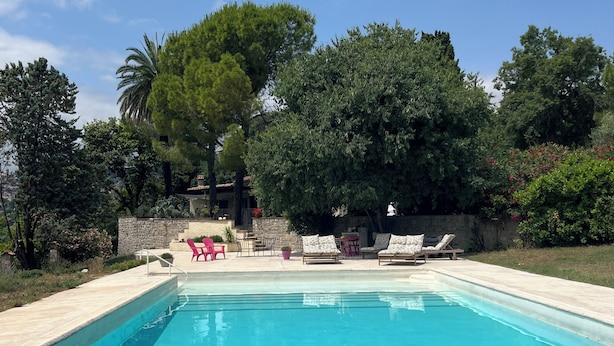 A swimming pool with lounge chairs and a stone wall. - Studio on the top floor of a traditional Grasse country house (Grasse)