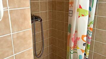 Une douche équipée d’un pommeau de douche et d’un rideau de douche aux couleurs vives.