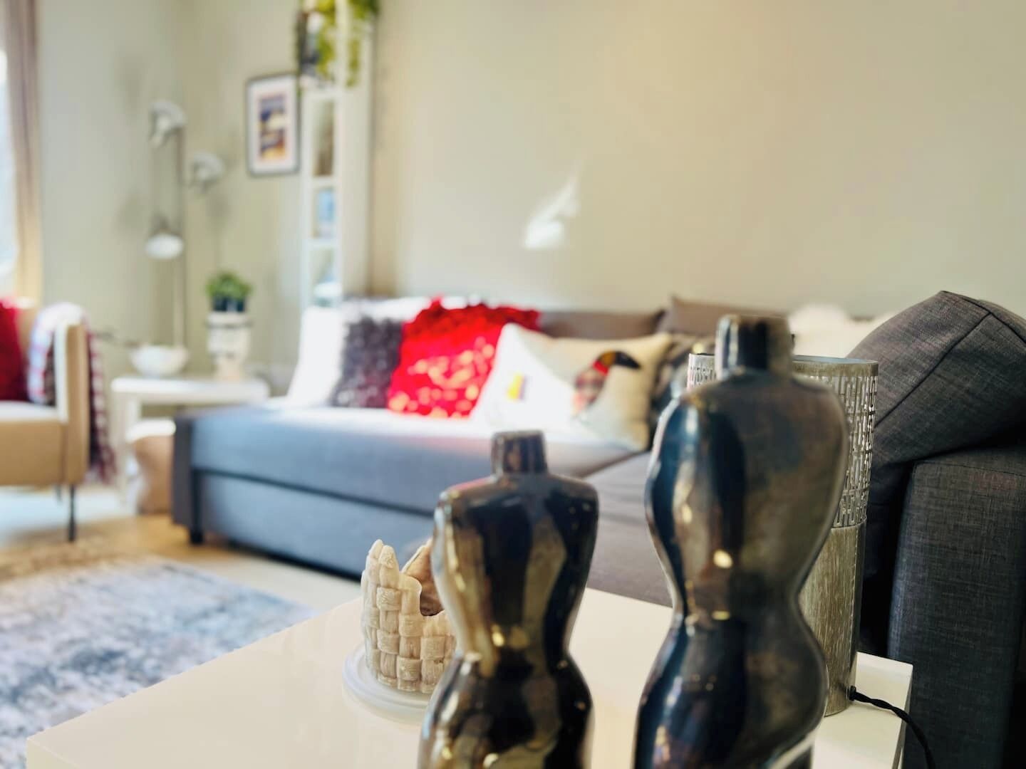 Een moderne woonkamer met een bank, salontafel en decoratieve elementen.