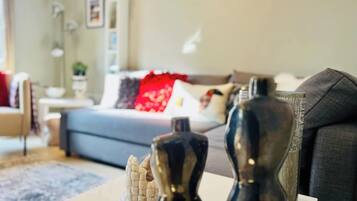Een moderne woonkamer met een bank, salontafel en decoratieve elementen.