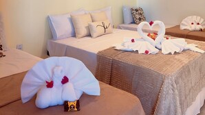 A hotel room with two beds, a hanging light fixture, and a wall-mounted air conditioner. - Pousada Caju Sansete  (Barreirinhas)