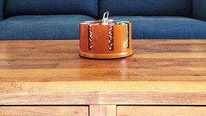 Ein Holztisch mit einem dekorativen Gegenstand vor einer blauen Couch und einem gerahmten Bild an der Wand.