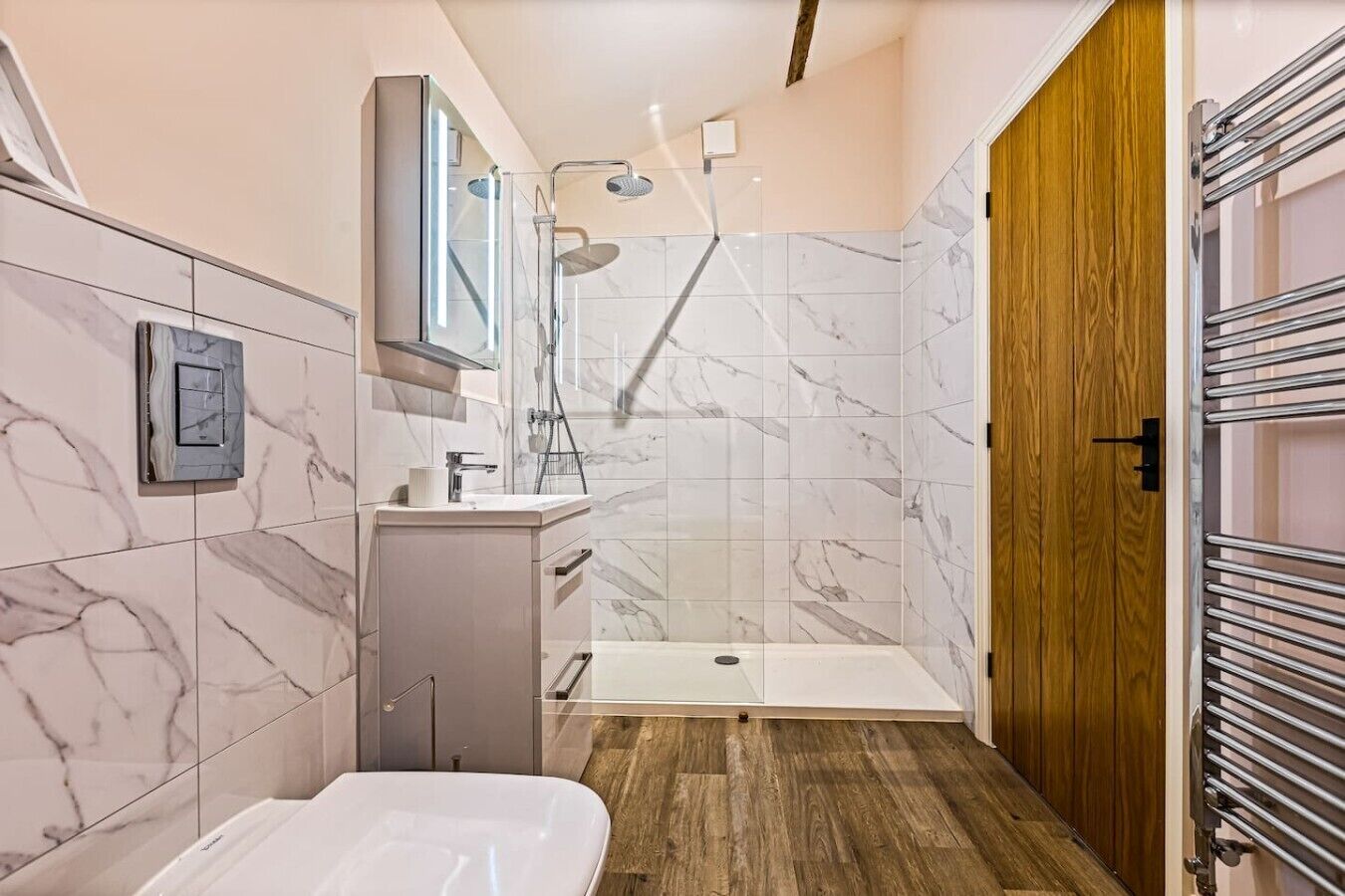 A modern bathroom with a shower, toilet, and sink.