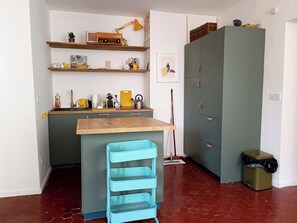 Eine kleine Küche mit einer Holz Arbeitsplatte, einem Spülbecken und einer blauen Küchenzeile.