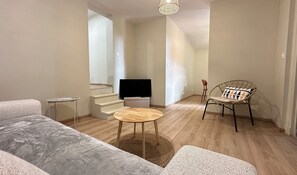A modern living room with a sofa, a round wooden table, a television, and a chair. - House for 8 with garden & terrace in Arcachon (Arcachon)