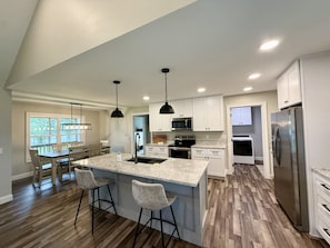 A spacious kitchen with a large island, modern appliances, and a dining area with natural light.