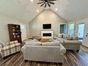 A living room with a fireplace, two sofas, a television, and a bookshelf.