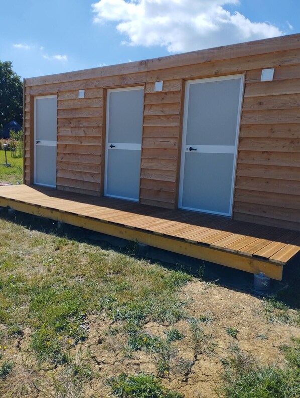 Una estructura de madera con tres puertas y un muelle de madera.