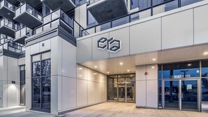Un edificio moderno con un logotipo destacado, una amplia entrada de vidrio y una fachada bien iluminada.