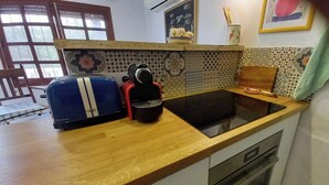 Una cocina con un tostador, un hervidor y un microondas en la encimera.