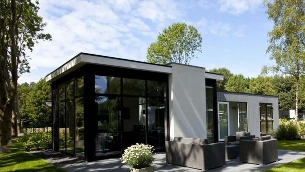 Un edificio moderno con amplios ventanales de vidrio, techo plano y diseño minimalista.