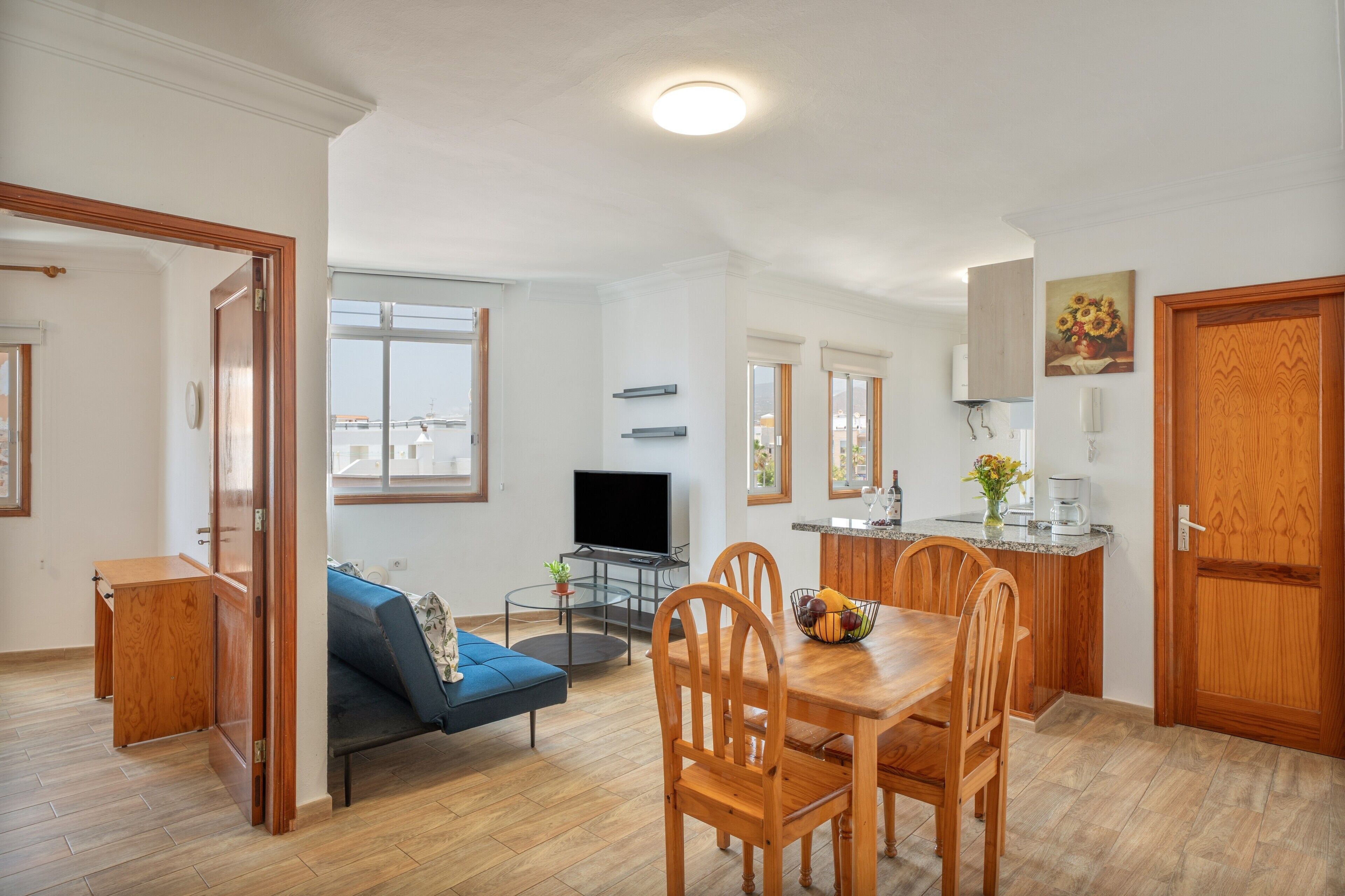 A modern apartment with a living room, dining area, and kitchen.
