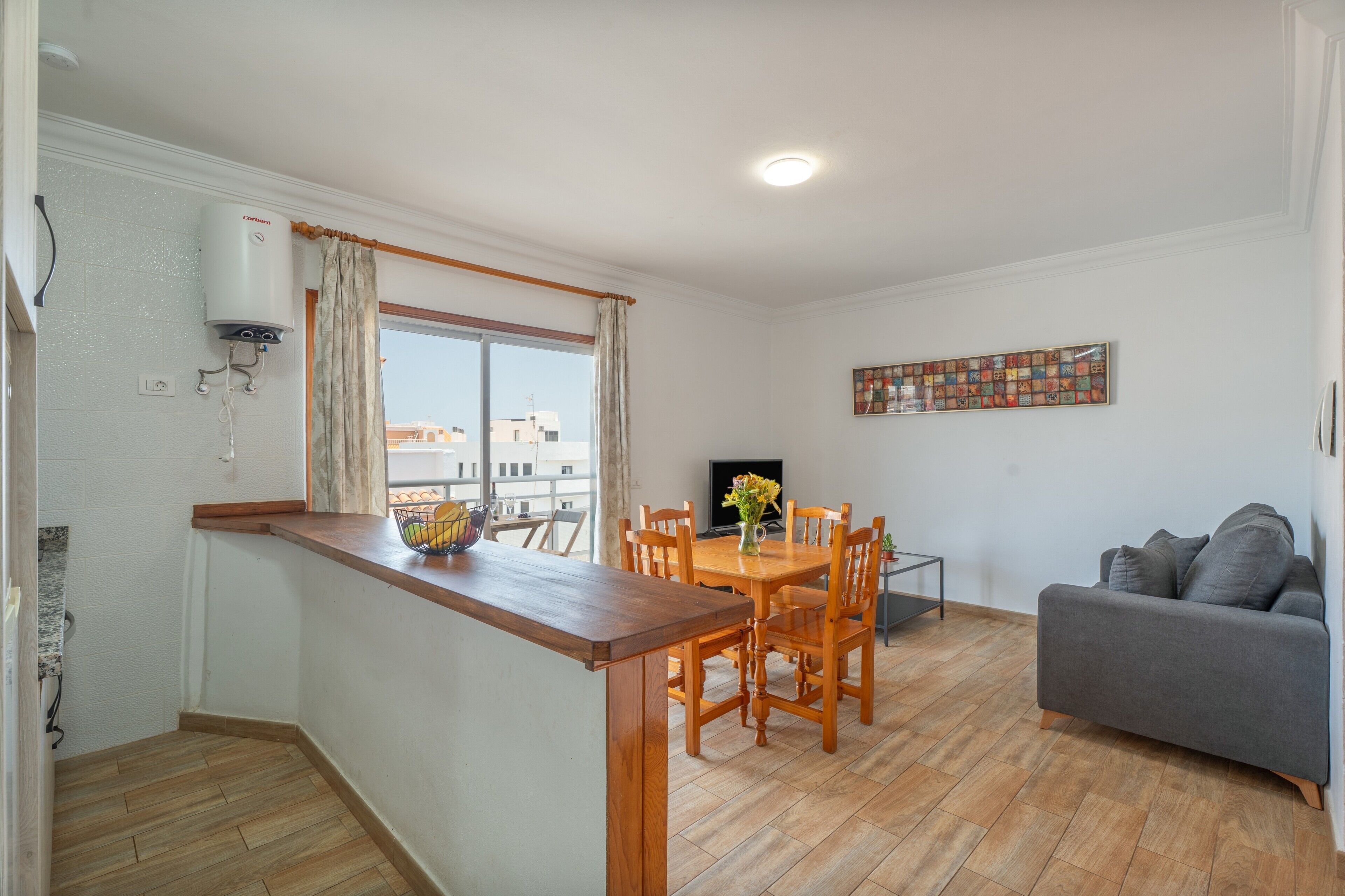 Un espacio habitable pequeño con kitchenette, comedor y zona de estar.