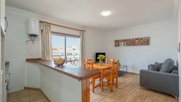 Un espacio habitable pequeño con kitchenette, comedor y zona de estar.
