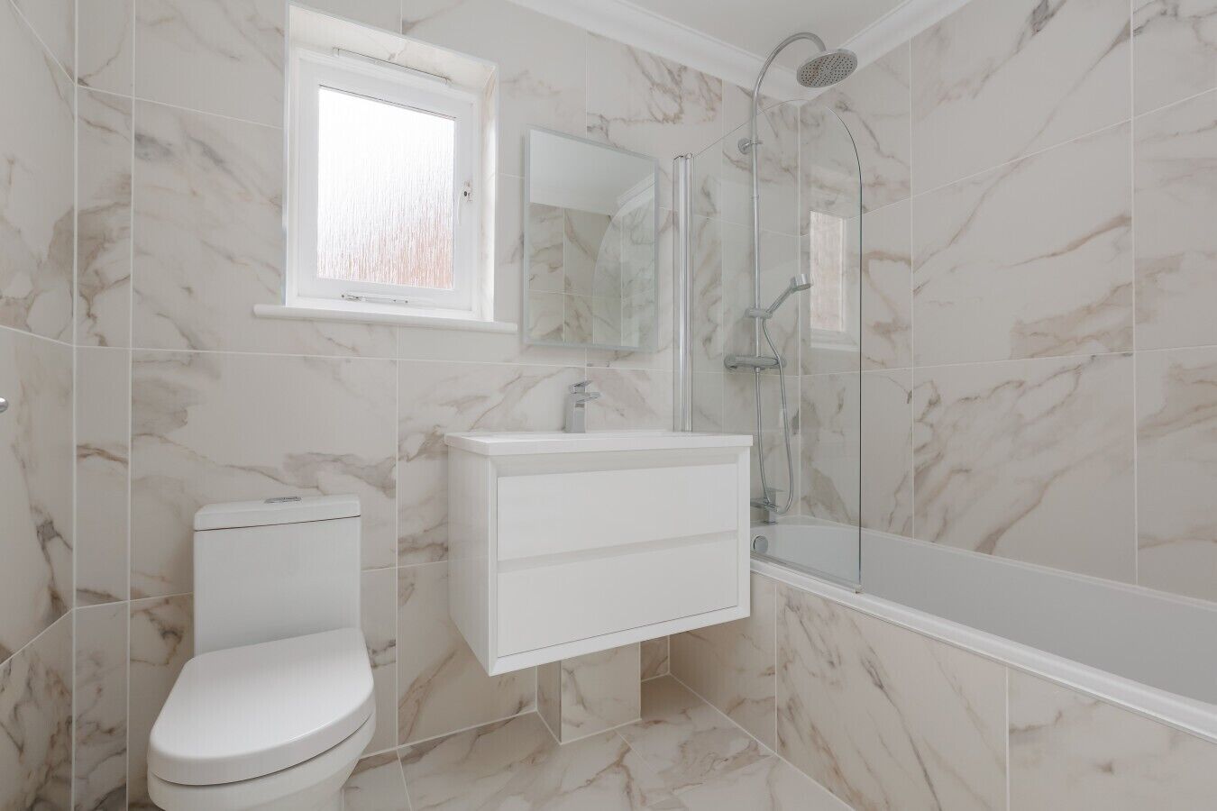 A bathroom with a toilet, sink, and shower.