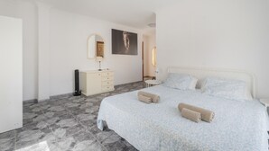 Un dormitorio con cama, cómoda, espejo y un cuadro en la pared.