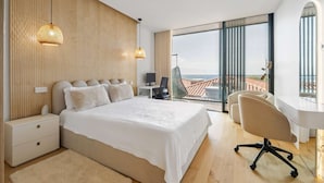 Une chambre d’hôtel moderne avec un grand lit, un bureau et une vue sur la ville.