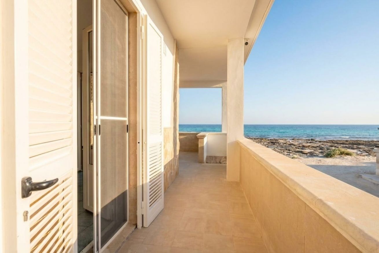 Ein Gang, der zu einem Balkon mit Blick auf das Meer führt.