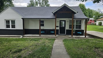 A single-story building with a porch, a black door, and a number '415' on the front.