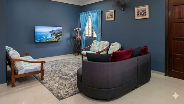 A living room with a sofa, armchairs, a TV, a window with curtains, and a fan.