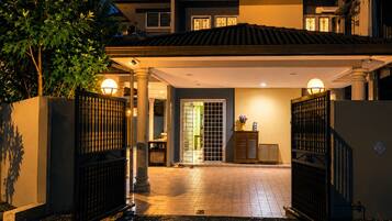 A two-story house with a covered driveway and gated entrance.