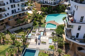 A multi-story hotel with a rooftop pool, outdoor seating, and lush landscaping. - Allonbay Aster 6 - Sea View & Private Jacuzzi (Villajoyosa)