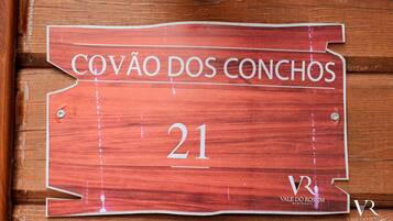 A wooden sign with the text 'COVÃO DOS CONCHOS' and the number '21' on it.
