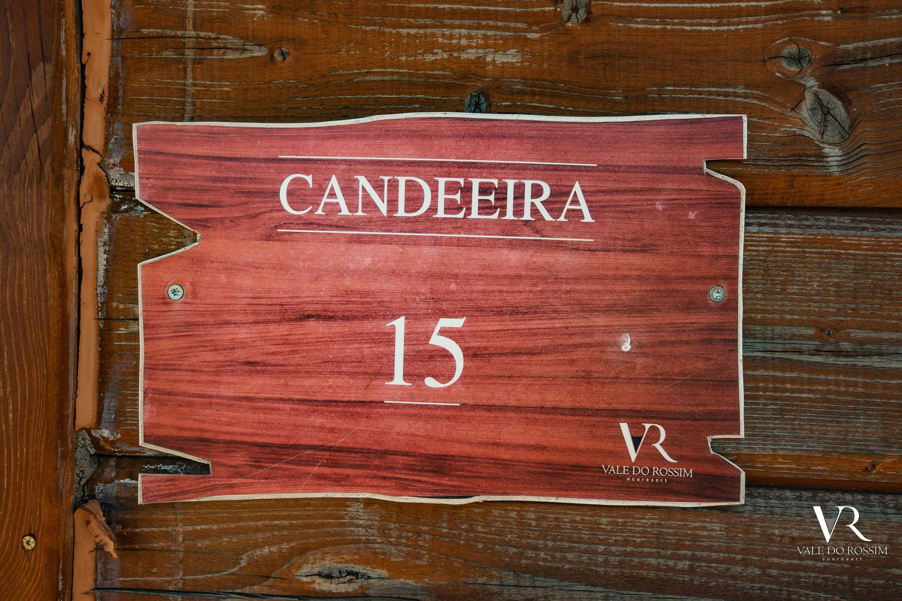 Ein Holzschild mit der Aufschrift 'CANDEIRA 15' und 'VALE DO ROSSIM', das Zimmernummer und Hotelname angibt.