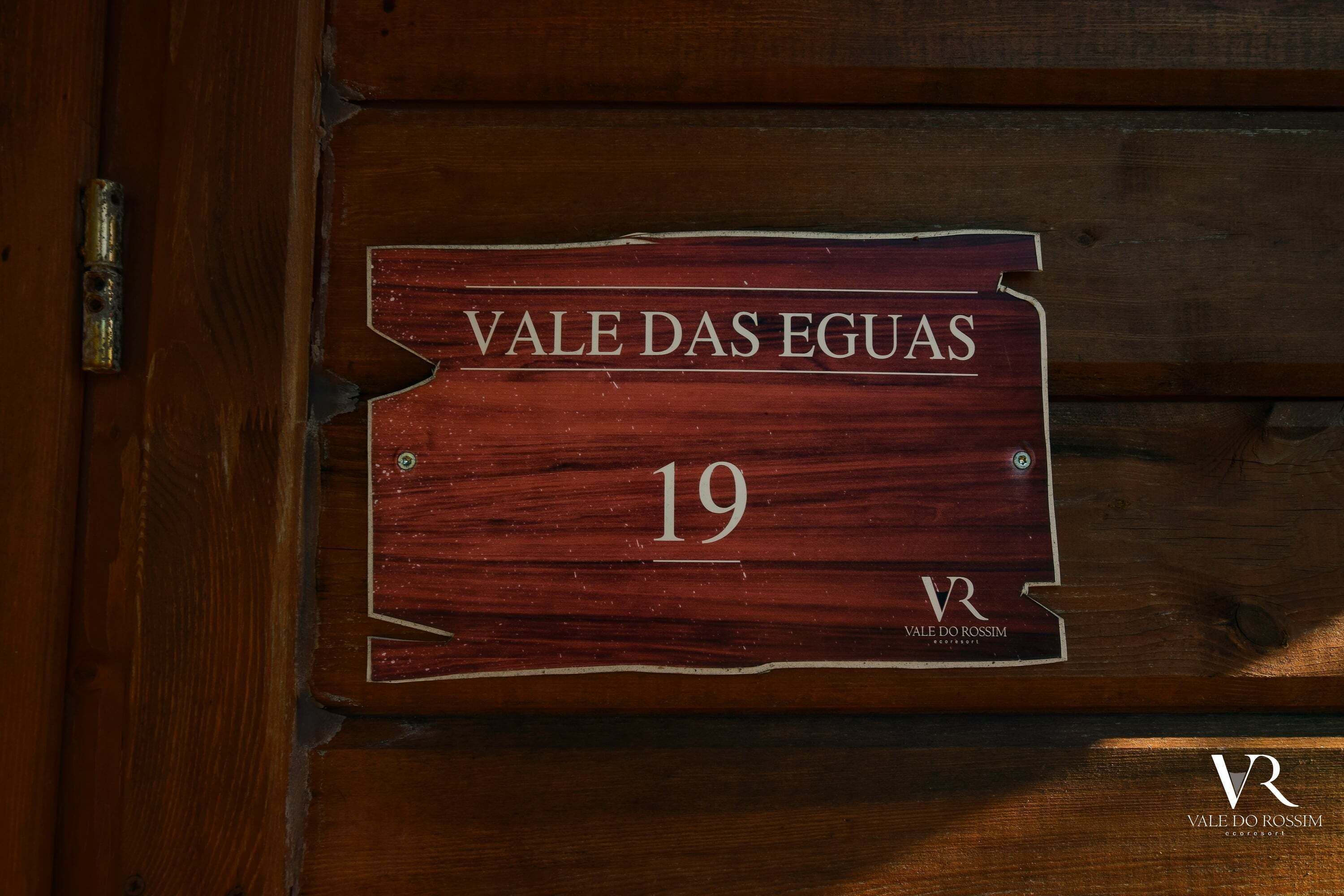 Una puerta de madera con un cartel que dice 'VALE DAS EGUAS 19' y el logotipo 'VALE DO ROSSIM' en la parte inferior.
